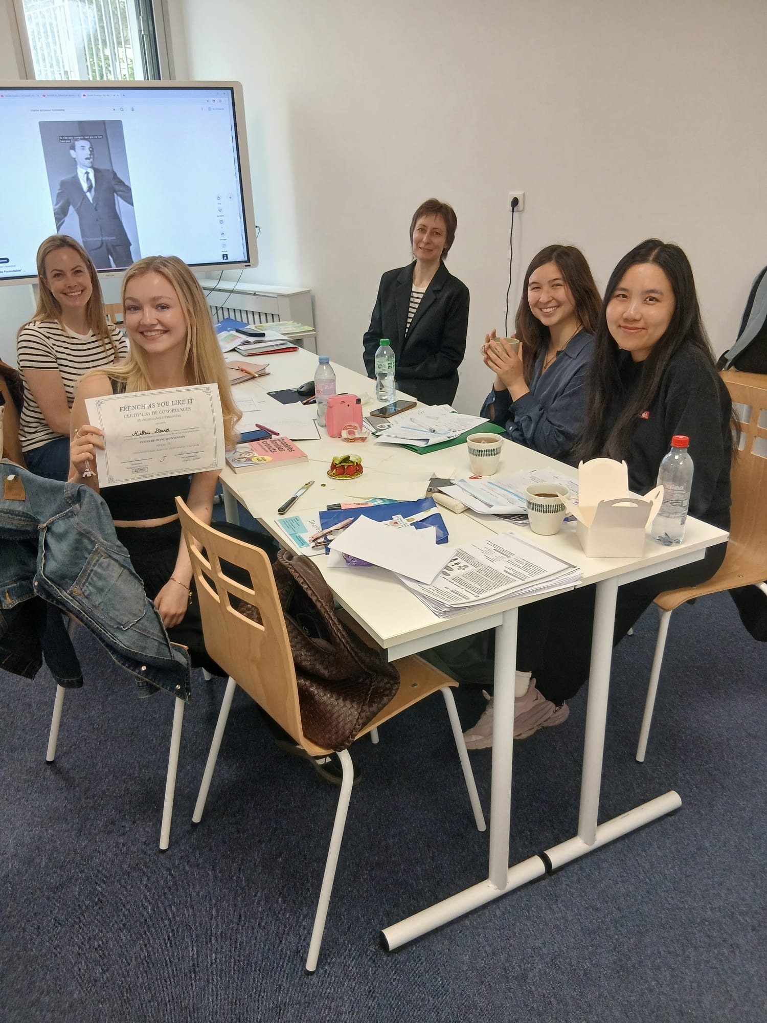 A student receiving her certificate at the end of an afternoon French course in Paris